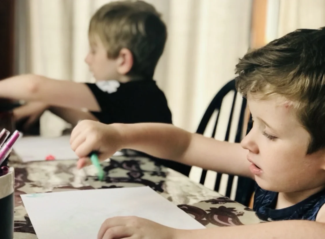 Two boys drawing at a table